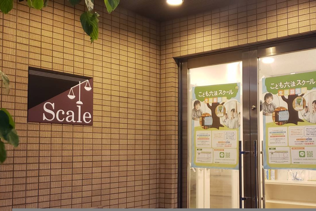 建物1階の入口。壁にScaleの看板が掲げられたガラスの扉